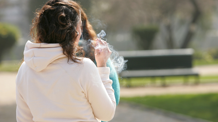 Mujer fumando en una plaza 
