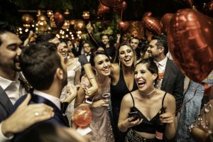 Groom and wedding guests laughing during party