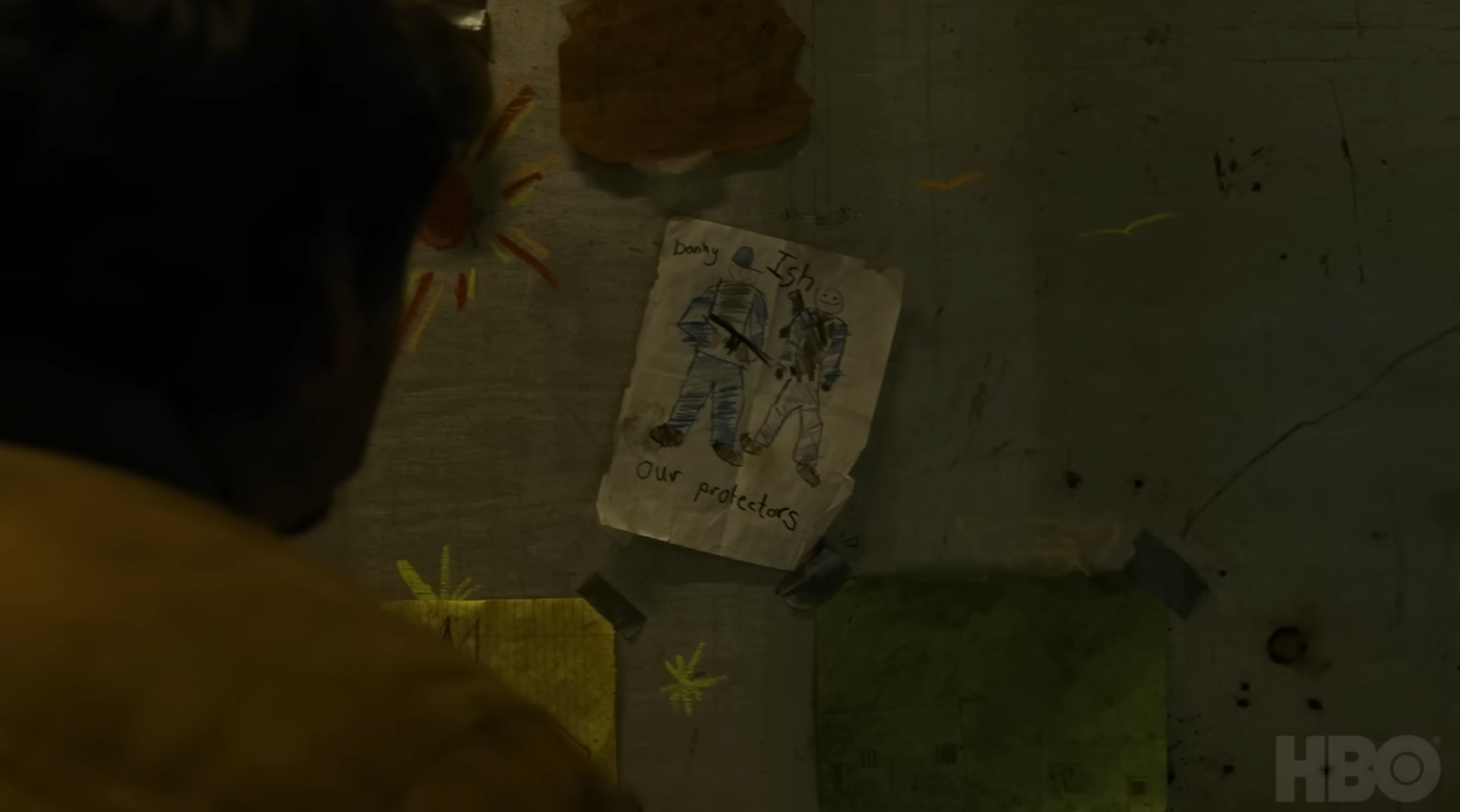 Captura de The Last of Us: Joel mira el dibujo en la pared de Ish y Danny que dice "nuestros salvadores".