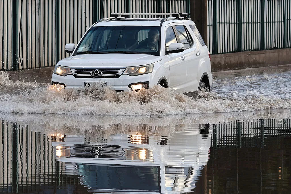 SANTIAGO, CHILE - JULY 18: A motorist crosses a flooded street after heavy rains affected the metropolitan area of Santiago on July 18, 2026 in Santiago, Chile. Chile is affected by heavy rains, causing damage in the central and southern areas of the country. According to the authorities, rain and snow are expected until July 23. (Photo by Marcelo Hernandez/Getty Images)