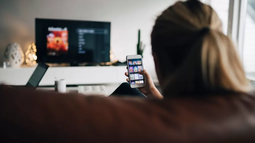 Viendo tele y celular GettyImages-944229620 web