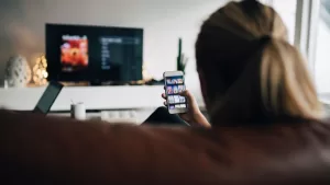 Viendo tele y celular GettyImages-944229620 web